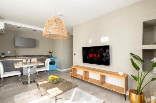Wolf Suites في أنطاليا: غرفة معيشة مع تلفزيون على الحائط