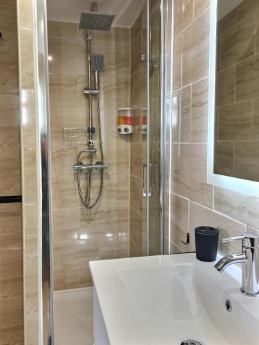 une salle de bain avec un lavabo et une douche dans l'établissement Bleu Lavande 1 - Appartement cosy ambiance village, à Istres