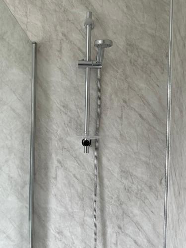 een douche met een douchekop in de badkamer bij House for Contractors and Families in Aldershot