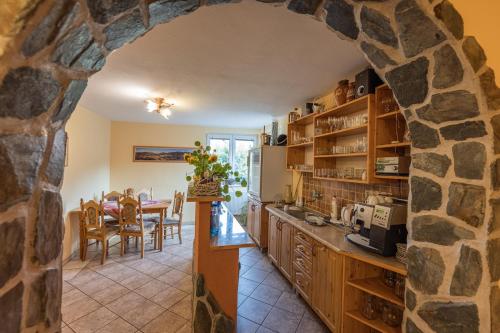 a kitchen and dining room with a stone wall at Penzion JAS in Zuberec