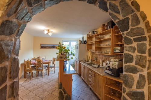 a kitchen and dining room with a stone wall at Penzion Jas in Zuberec