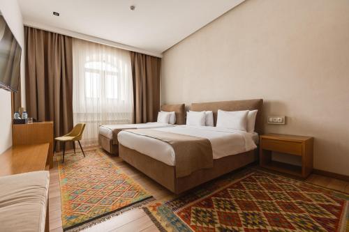 a hotel room with two beds and a window at HOTEL MODERNO & Spa in Tashkent