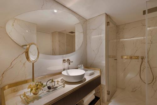 a bathroom with a sink and a mirror and a shower at Theatron Jerusalem Hotel & Spa - MGallery Collection in Jerusalem