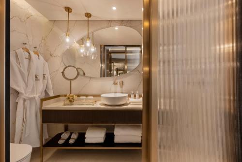 a bathroom with a sink and a mirror at Theatron Jerusalem Hotel & Spa MGallery Collection in Jerusalem