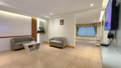 a hospital room with two chairs and a flat screen tv at Mount Polaris Suites & Spa in Kalimpong