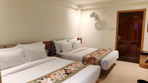 a hotel room with two beds in a room at Mount Polaris Suites & Spa in Kalimpong