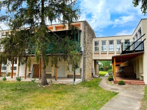 a building with a tree in front of it at Balaton Breeze Apartman in Fonyód