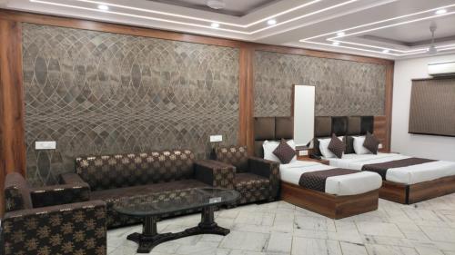 una camera con due letti, un divano e un tavolo di HOTEL SINGH CONTINETAL a Nuova Delhi