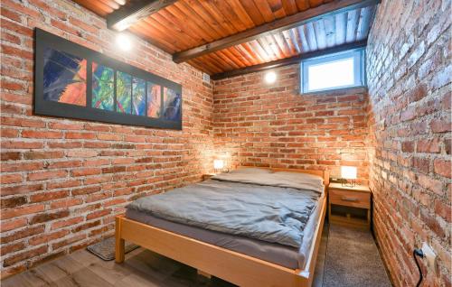 a brick walled bedroom with a bed and a nightstand at Gorgeous Home In Jalsje With Sauna in Martinišće