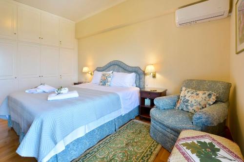 a hotel room with a bed and a chair at Corfu Ionian Blue in Anemómylos
