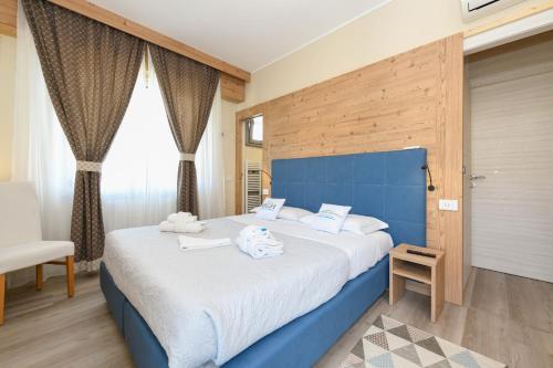 een slaapkamer met een groot bed met een blauw hoofdeinde bij Lugana Family Stay in Sirmione