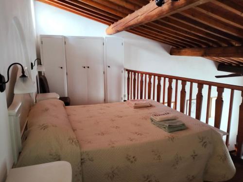 una camera con letto in una stanza con soffitti in legno di il nido APUS Architect Apartment a Montevarchi