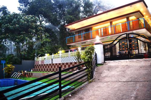 a house with a fence in front of it at Arabian Nights Munnar in Munnar