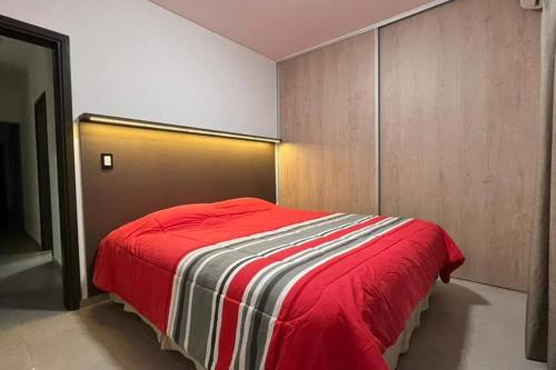 ein Schlafzimmer mit einem Bett mit einer roten Decke in der Unterkunft Pellegrini Home in Godoy Cruz