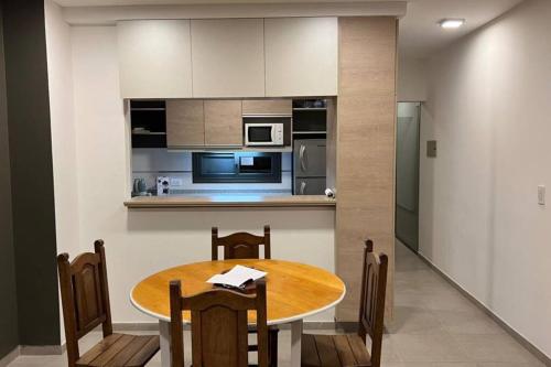 eine Küche und ein Esszimmer mit einem Holztisch in der Unterkunft Pellegrini Home in Godoy Cruz