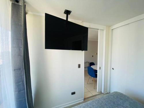 a bedroom with a flat screen tv on a wall at Confortable Apartamento para 3 in Santiago