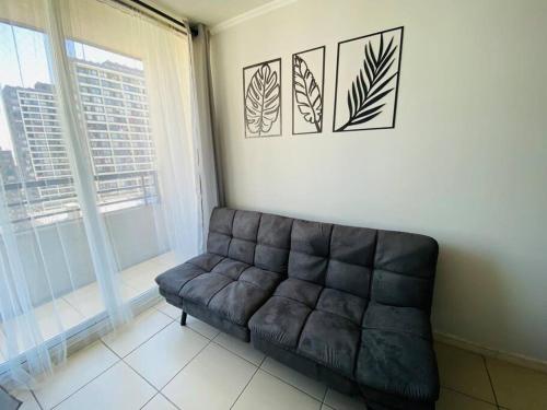 Confortable Apartamento para 3 في سانتياغو: أريكة من الجلد في غرفة المعيشة مع نافذة