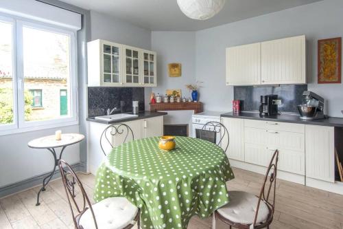 une cuisine avec une table et des chaises dans une cuisine dans l'établissement Ti Laouen, Maison traditionnelle Bretonne, à Les Brulais