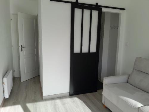 a living room with a black door and a couch at Chez Maryline in Chalonnes-sur-Loire