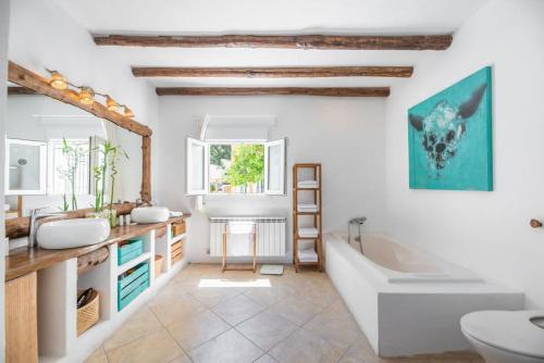 bagno con 2 lavandini e vasca di Villa en San José con vistas al mar, piscina y 7 habitaciones a Cala Vadella