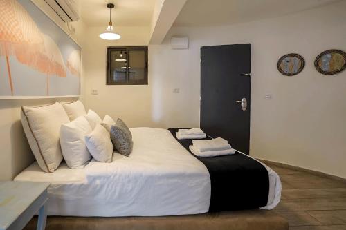 a bedroom with a large bed with white sheets and pillows at YalaRent Cliff side villa with private pool in Eilat