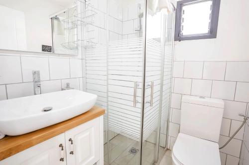a white bathroom with a sink and a toilet at YalaRent Cliff side villa with private pool in Eilat