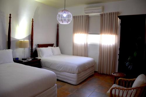 Habitación de hotel con 2 camas y lámpara de araña. en Turtle Bay Inn, en Lajas