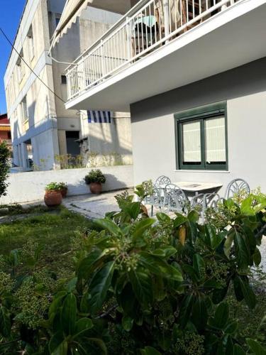 a house with chairs and a table in a yard at Olympus and Sea View Apartment in Platamonas