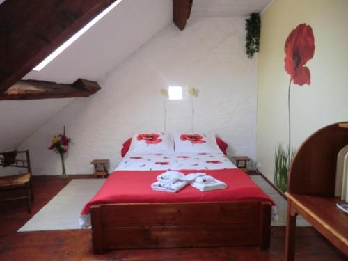 1 dormitorio con 1 cama con sábanas rojas y almohadas rojas en La Mez a Nine chambres d'hôtes, en Buxières-sous-Montaigut