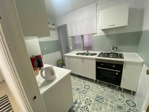 uma cozinha branca com um lavatório e um fogão em El Antequerano em Antequera