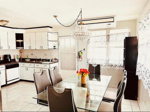 a kitchen with a glass dining table and chairs at The Calle Retreat by the Airport & Beach in Carolina