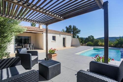 eine Terrasse mit einer Pergola und einem Pool in der Unterkunft Villa26 in Montauroux