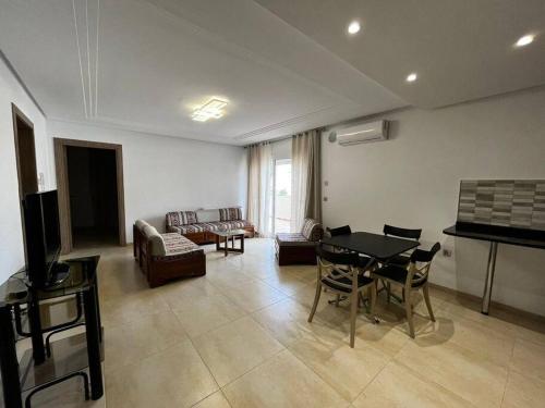 a living room with a table and a couch at 2 Bedrooms apartment swimming pool in Monastir