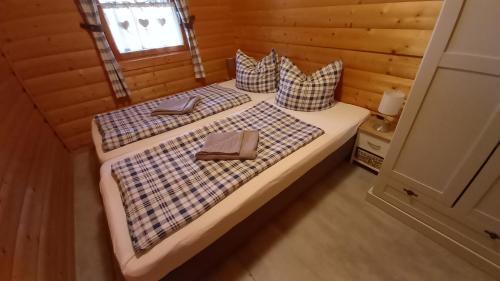 um quarto com 2 camas num chalé de madeira em Ferienhaus Hensel em Großzerlang