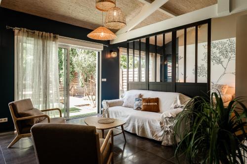 un soggiorno con un letto e un tavolo di Villa Eden Bleu - Piscine et jacuzzi privé - Logement classé 4 étoiles a Biscarrosse