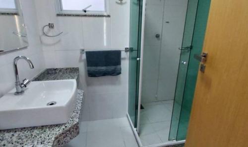a bathroom with a sink and a shower at Apartamento de 3 quartos com vista para o mar in Arraial do Cabo