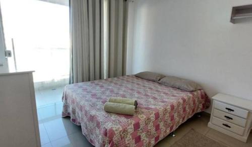 a bedroom with a bed and a window at Apartamento de 3 quartos com vista para o mar in Arraial do Cabo