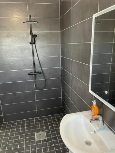 a bathroom with a shower and a sink and a mirror at Kassikäpa villa in Haapsalu