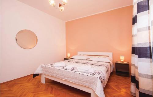 a bedroom with a bed and a mirror on the wall at Cozy Apartment In Sibenik With House Sea View in Krapanj