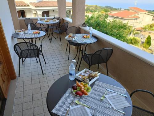 uma varanda com mesas e cadeiras com frutas em B&B villa orchidea em Ricadi