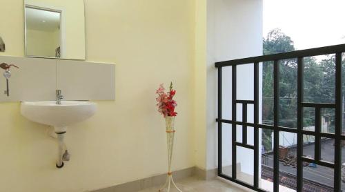 a bathroom with a sink and a window at Thanungattil Towers in Changanācheri