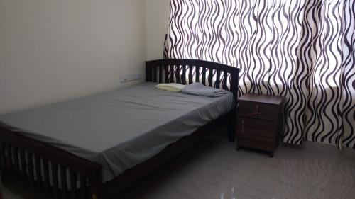 a small bed in a room with a zebra print wall at Thanungattil Towers in Changanācheri