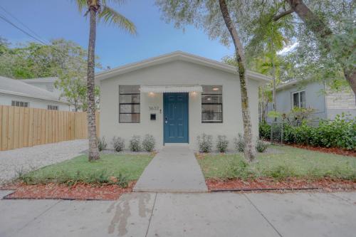 een wit huis met een blauwe deur en palmbomen bij Big Family Reunion Upscale 8-5 in Historic Coconut Grove in Miami