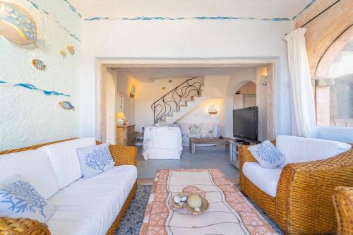 a living room with white couches and a tv at Villa Ilda in Cannigione