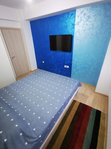 a bedroom with a bed with a blue wall at Tea Apartment in Kumanovo