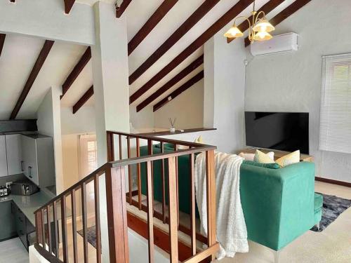 sala de estar con escalera y sofá verde en Separate entry cozy Guesthouse en Hillcrest