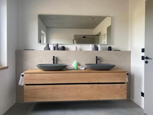 2 lavabos en un mostrador de madera en un baño en Neubau Grüner Wolpertinger Designwhg 106qm Barrierefrei en Breitbrunn am Chiemsee