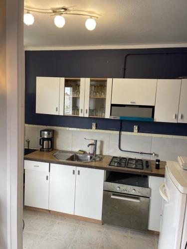 a kitchen with white cabinets and a stove top oven at A 2 pas de la gare in Chalon-sur-Saône