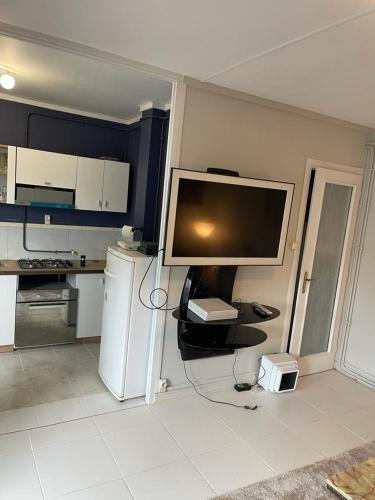 een keuken met een grote tv en een koelkast bij A 2 pas de la gare in Chalon-sur-Saône