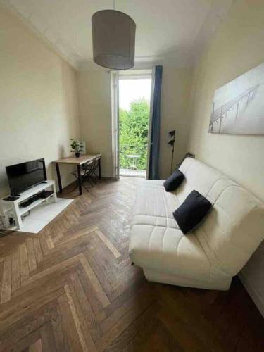 un salon avec un canapé blanc et une télévision dans l'établissement Lovely appartment with 2 bedrooms Nice Libération, à Nice